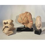 A group of three Indian pink and cream coloured stone Shiva fragments, 13th/14th century style,