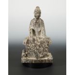 A Chinese mottled dark stone seated Buddhist deity, in Wei Dynasty style,