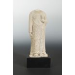 A Chinese sandstone figure of an enrobed figure, headless, in early Tang style,