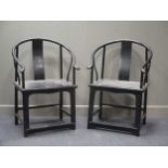 A pair of Chinese hard wood hoop back arm chairs