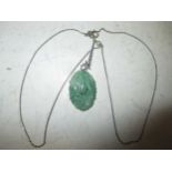 A carved jadeite pendant and chain, cased