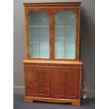 A yewwood effect glazed top bookcase or display cabinet, 181 x 106 x 33cm