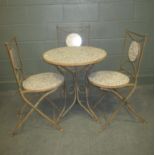 A wrought iron garden table with blue and white tiled top together with three matching folding