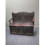 A 17th century style box seat hall settle with hinged seat and scroll arms, 106 x 121 x 50cm