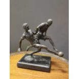 After Milo, A modern bronze sculpture of two footballers challenging for the ball, on a black marble