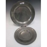 A large 17th century pewter charger, 44cm dia., together with four smaller pewter plates