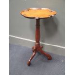 A late Victorian oak wine table, the dished C scroll top with carved detail on a turned column and S