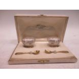 A pair of French metalwares silver gilt and ceramic salts and spoons, cased (4)