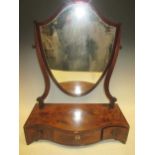A George III shield shaped toilet mirror, the serpentine base fitted with three drawers