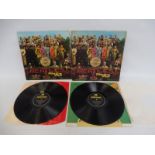 Two Beatles Sgt. Pepper LPs, one first press plus insert, visible flaps on the gatefold sleeve,