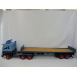 A large scale wooden model of an articulated Scania flat bed lorry, approx. 60" long.