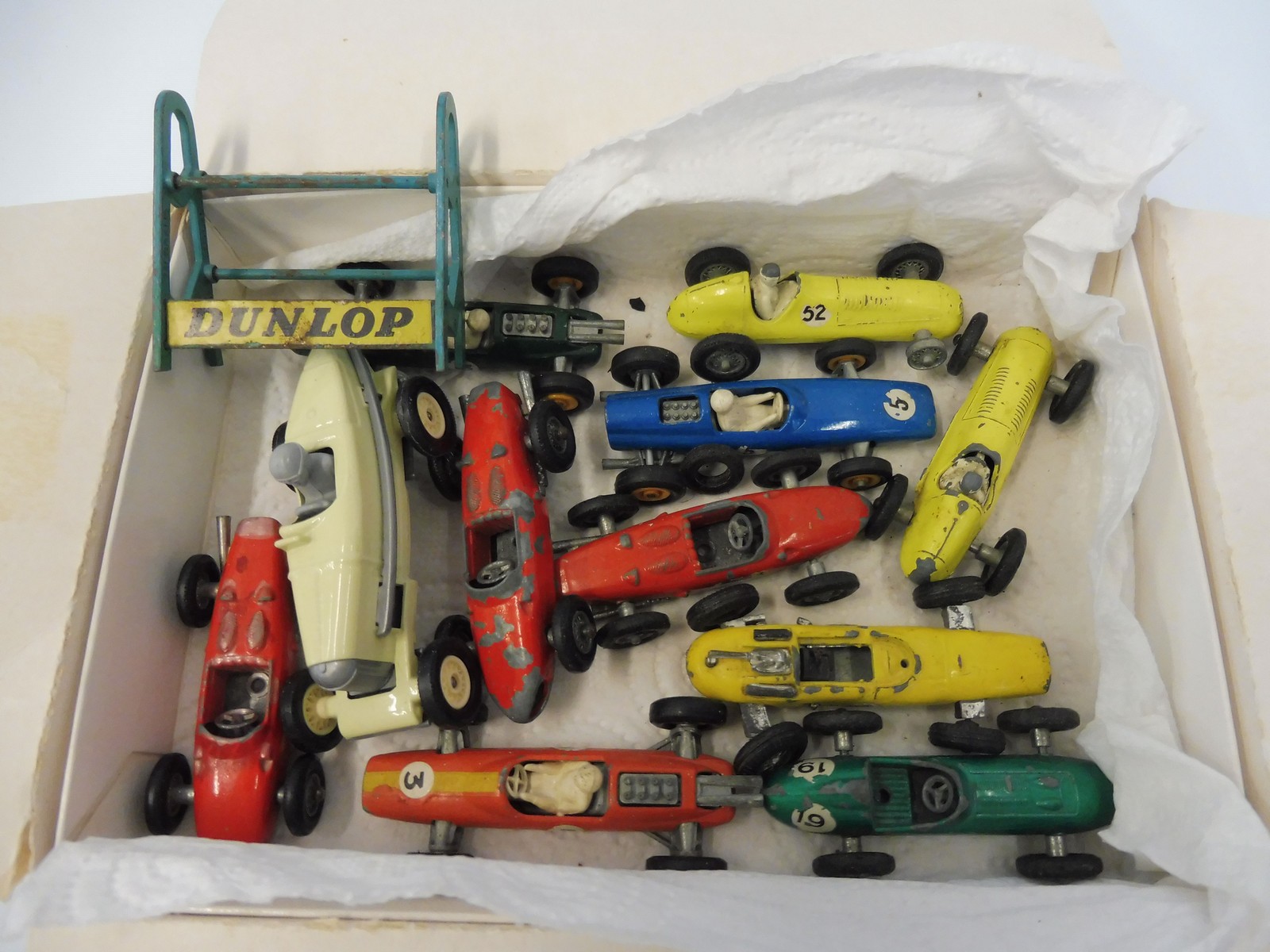 A box of early Matchbox racing cars, Dunlop stand etc.