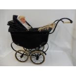 A circa 1950s small doll's pram with tassled canopy, with a later plastic doll.