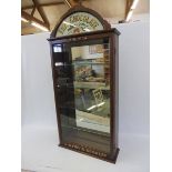 A wall mounted front opening display cabinet with carved words to the base of the door: 'J.S.