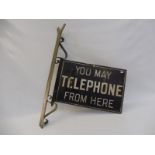 A 'You May Telephone From Here' double sided enamel sign on unusual pivot bracket, a very early