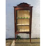 An Edwardian inlaid mahogany bow fronted display cabinet with stained glass leaded panel.