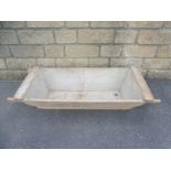 A 19th Century pine flour trough with shaped carrying handles, 51 1/2" w x 10" h x 19 3/4" d.