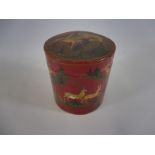 A rare 19th Century papier mache and red lacquered lidded cylindrical pot naively decorated with