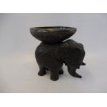 An early carved ebony elephant surmounted by a carved coconut half shell inset with a white metal
