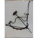 A large early 18th Century wrought iron downhearth chimney crane, with decorative scroll work,