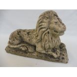 A weathered garden ornament of a primitive recumbant lion, 22" w x 14 1/2" h x 8" d.