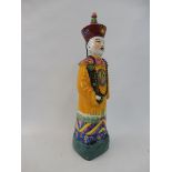 An Oriental ceremonial figure glazed in unusual bright colours, 15" h.