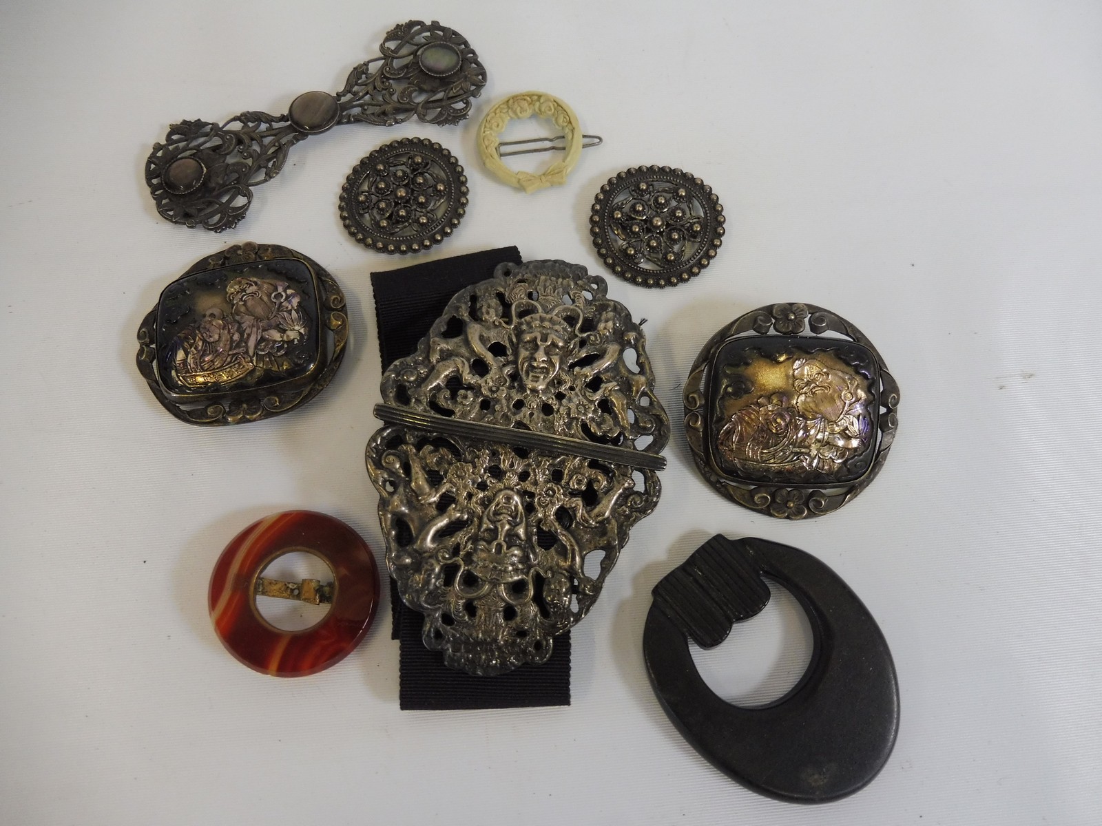 A selection of unusual buckles and brooches including a pierced silver two piece nurse's buckle.