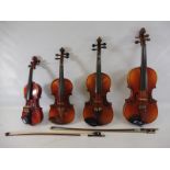 Four cased violins from quarter size to full size.