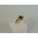 A 9ct gold ring set with a cental dark coloured stone surrounded by cz, weight approx. 2g.