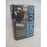 A personally signed Stewart Copeland (of Police fame) book titled 'Strange Things Happen', signed