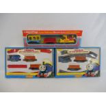 A Haycraft Junior Railways electric locomotive plus two Hornby Thomas the Tank Engine train sets.