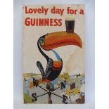 A Guinness advertising tea towel, mounted on board, depicting a toucan, 18 x 29".