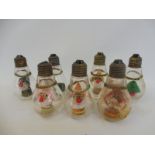 Seven original fairground light bulbs from a ride, with internal figures.