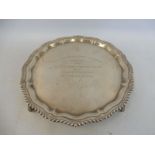 A silver salver with gadrooned border raised upon four scrolled supports, Birmingham 1964, bearing