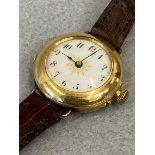 An 18ct gold ladies wristwatch with white enamel dial, on a leather strap.