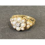 A Victorian gold ring (unmarked) set with a central diamond surrounded by seed pearls.