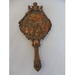 A decorative Victorian relief copper hand mirror depicting figures, signed 'Magie'.