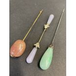 Two good quality hardstone mounted hat pins, one with jade end, plus a double ended pin, with