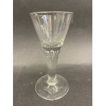A Georgian drinking glass with wide foot and teardrop to the stem.