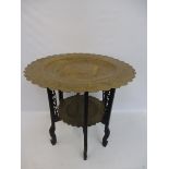 An Eastern brass topped two tier folding occasional table.