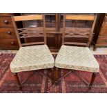 A pair of late Georgian mahogany and satinwood inlaid dining chairs with cross stretchers.