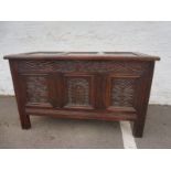 A 17th Century and later oak coffer with a panel depicting a primitive man.