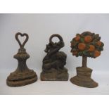 Three 19th Century cast iron doorstops including one in the form of a tree with flowers.