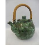 A studio pottery green glazed teapot with bamboo handle, signed to base.