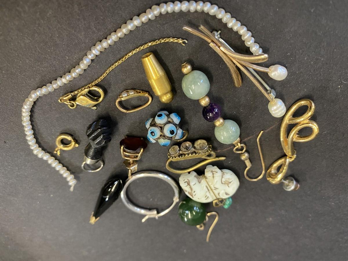 An interesting selection of jewellery including a 9ct gold brooch, various gems, single earrings