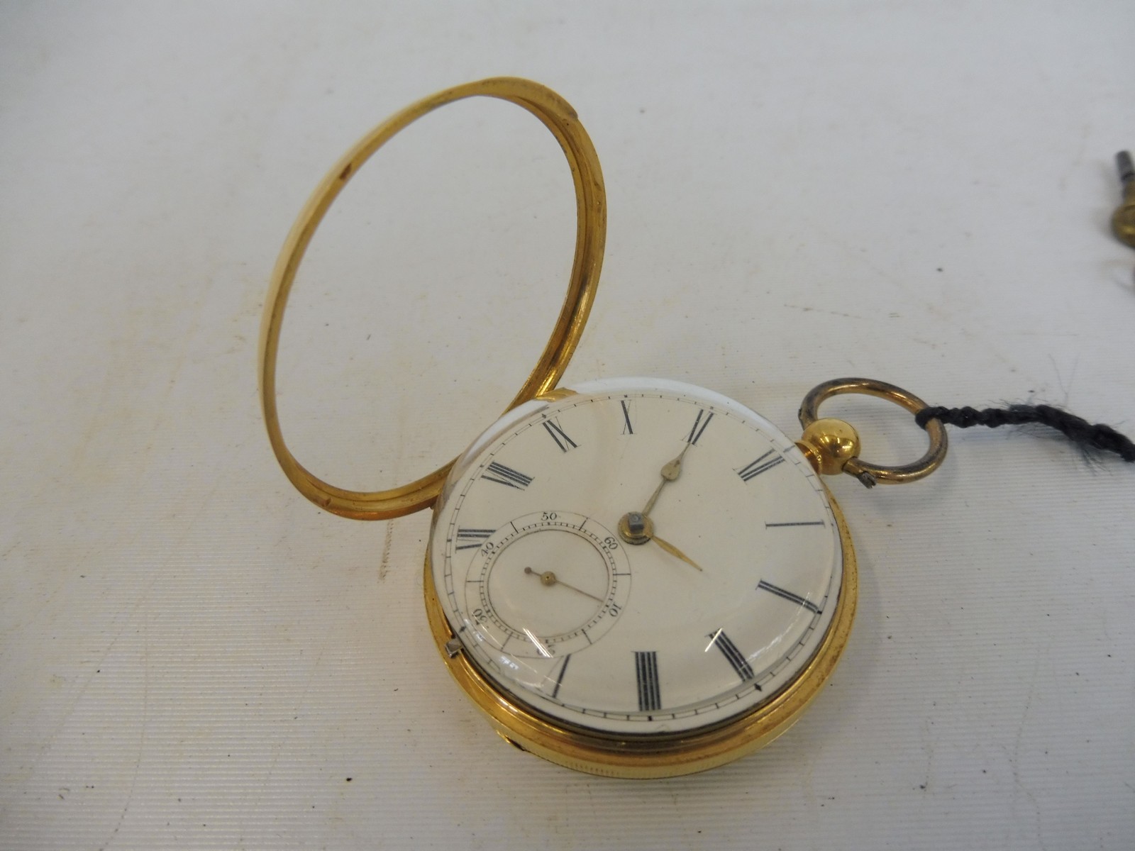 A gold pocket watch (possibly 18ct), with white enamel dial and subsidiary dial, complete with two