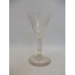 An 18th Century single drinking glass with finely engraved conical bowl and ribbed knop.