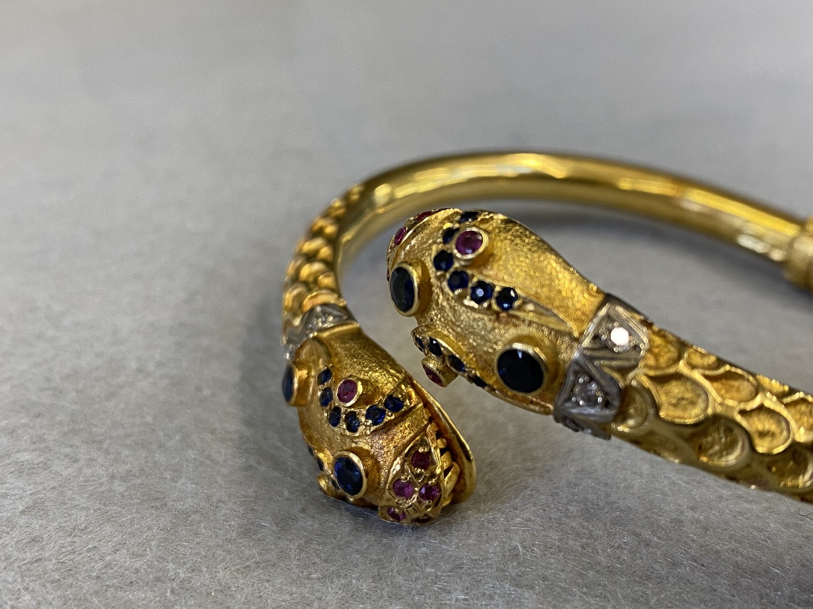 An 18k gold double headed serpent bangle, both heads encrusted with diamonds and semi-precious - Image 3 of 3