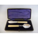A cased silver spoon and knife with ivory handles.
