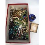 A shoebox full of assorted jewellery.